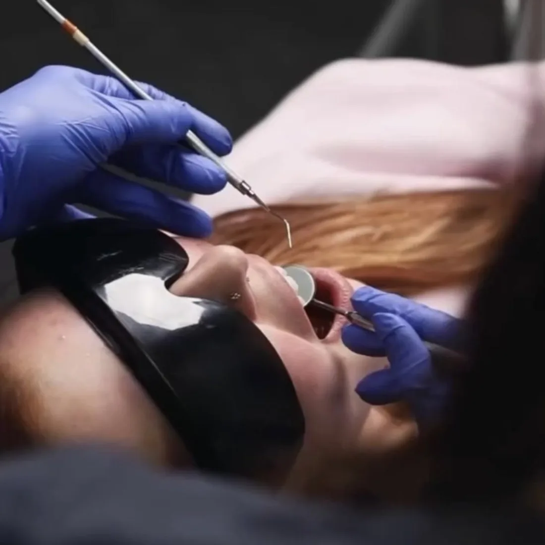 Dental hygienist gently cleaning a patient's teeth Dental hygienist gently cleaning a patient's teeth