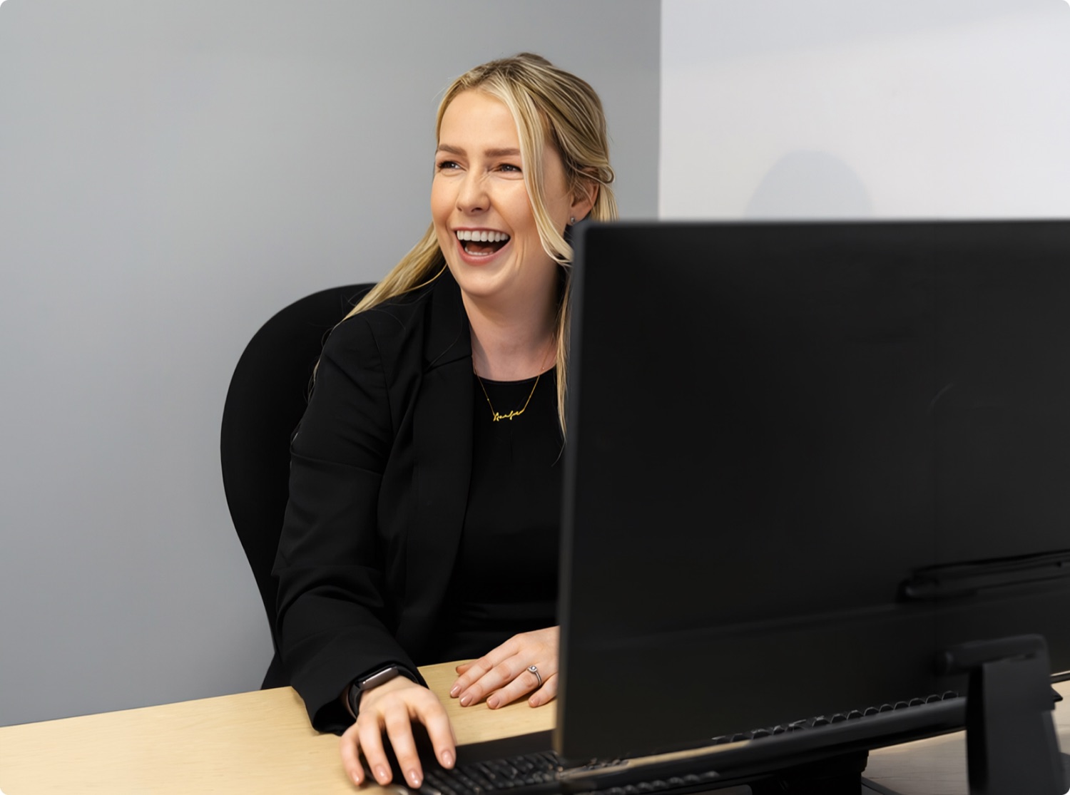 A Queensway Dental team member smiling at a reception desk A Queensway Dental team member smiling at a reception desk