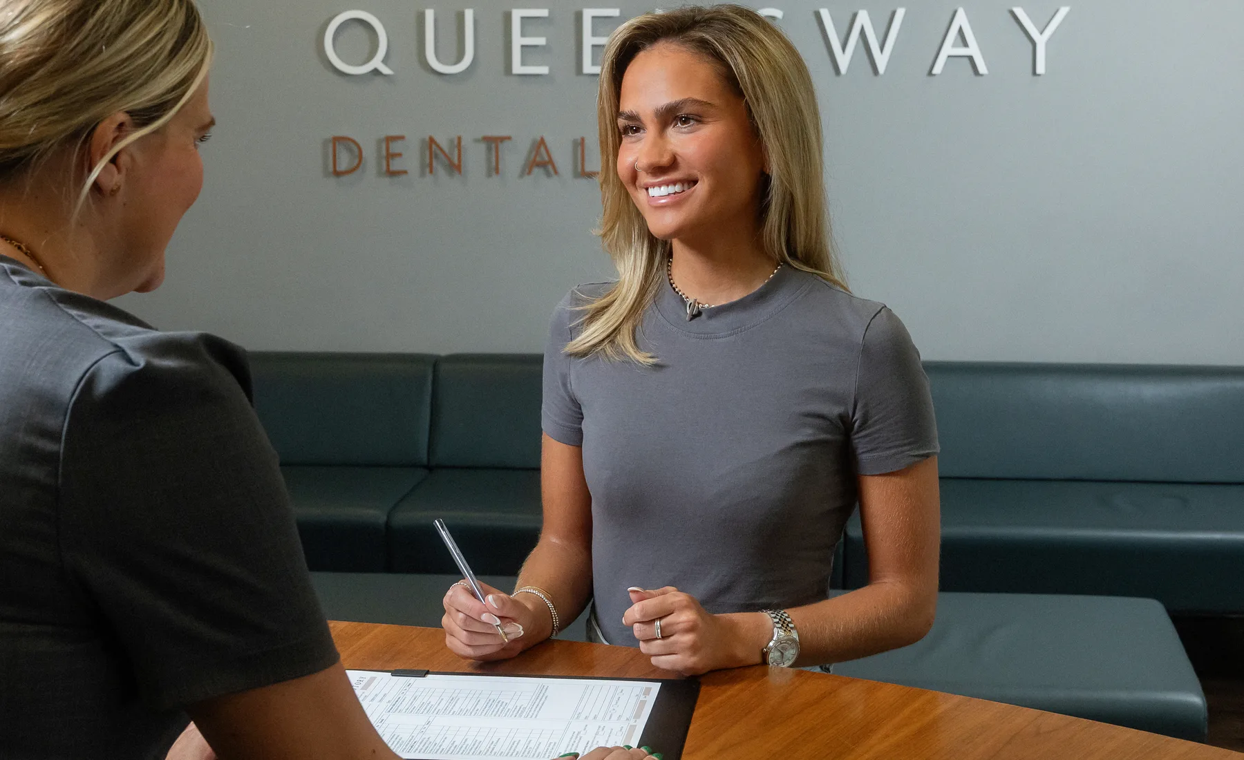 A patient being welcomed at Queensway Dental reception A patient being welcomed at Queensway Dental reception